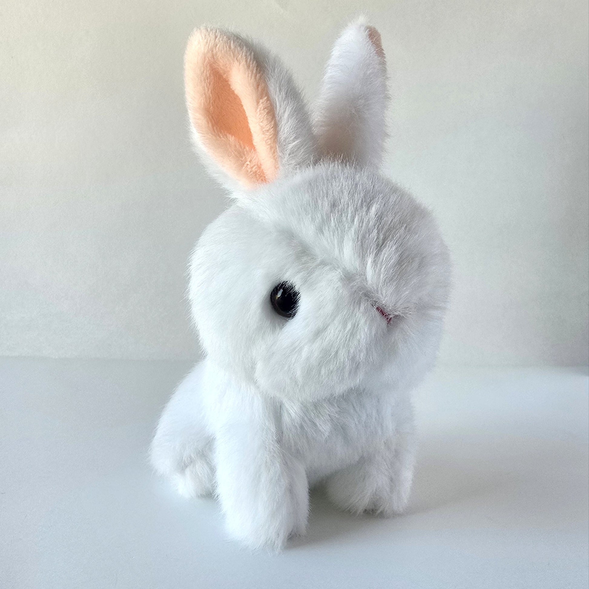 Front view of white bunny plush keychain showing soft microfleece fur, pale pink inner ears, and silver ball-chain against a white background