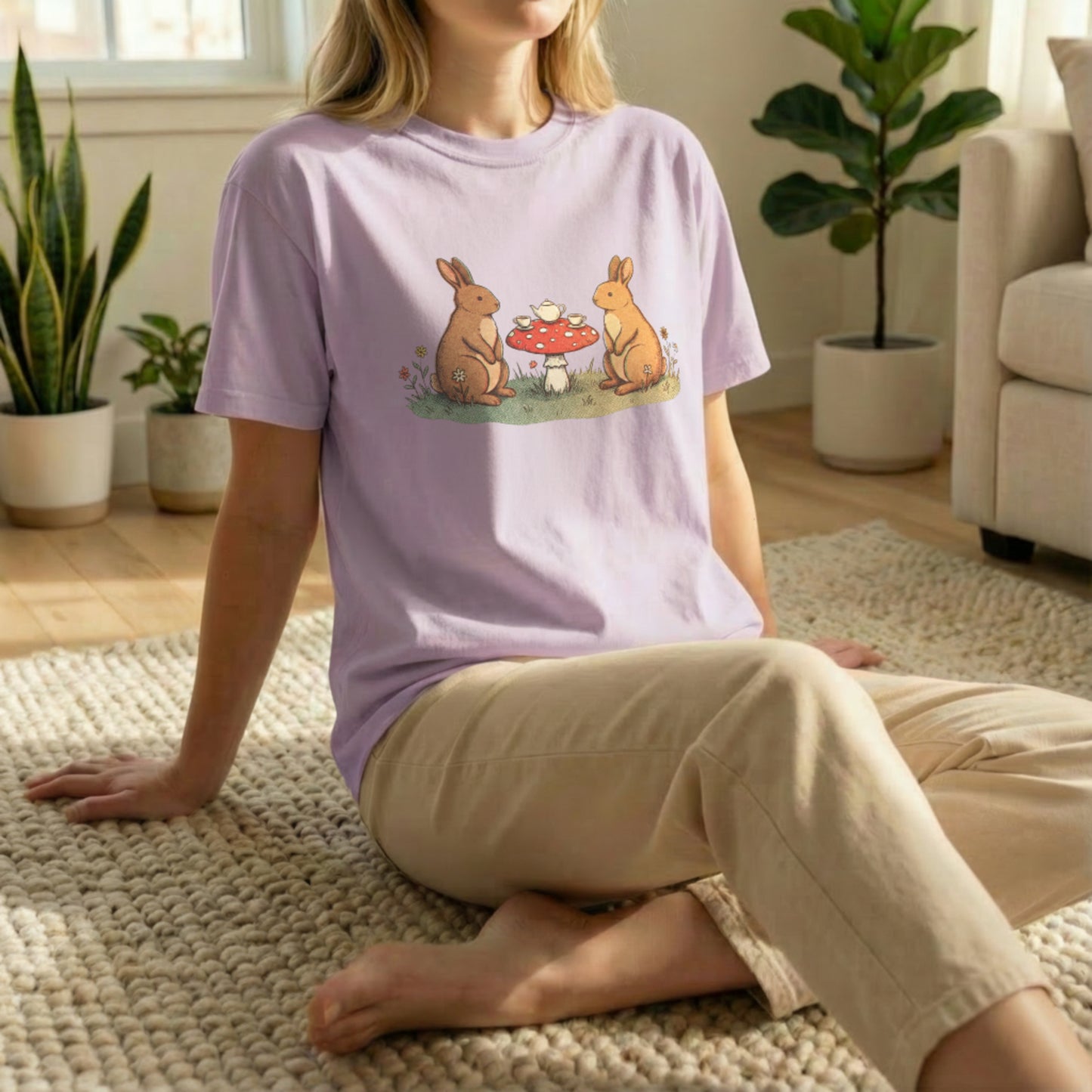 Bunny Picnic Tee shown in floor pose on orchid shirt with cozy illustrated bunny picnic artwork