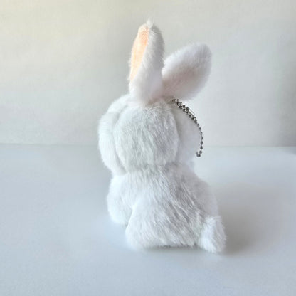 Back view of white bunny plush keychain highlighting its fluffy tail and ball-chain attachment against a white background