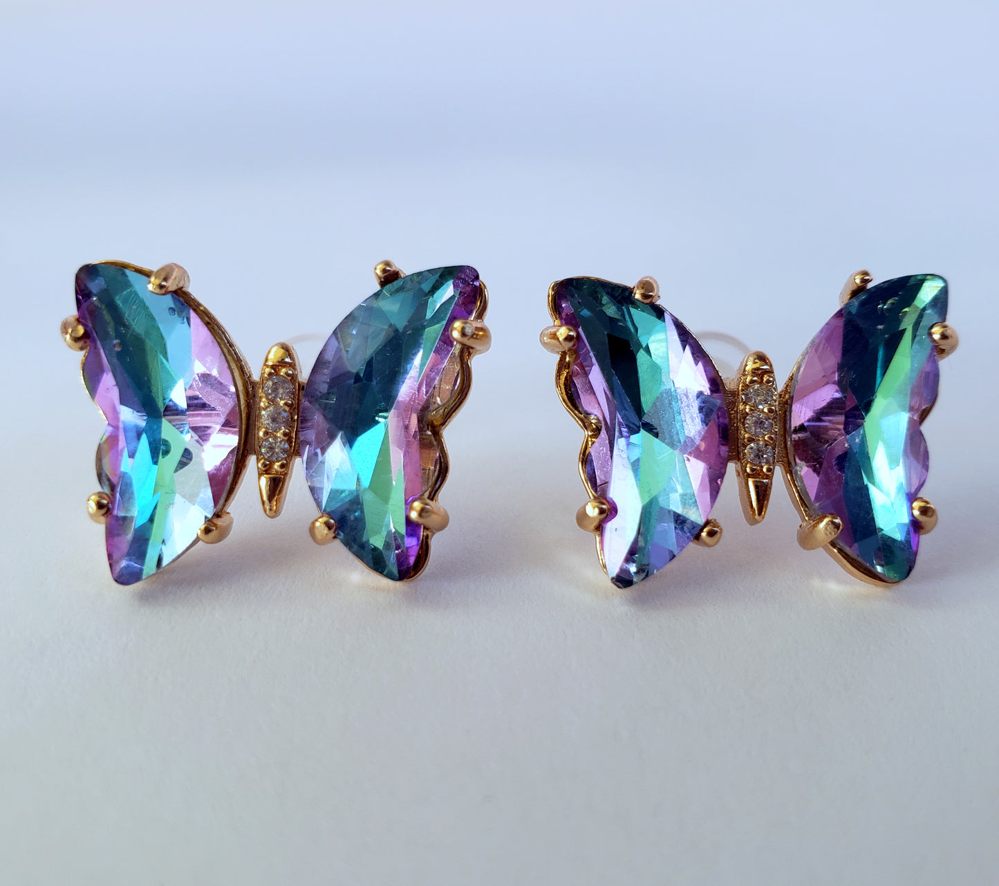 Crystal butterfly stud earrings in lilac ice blue on white background