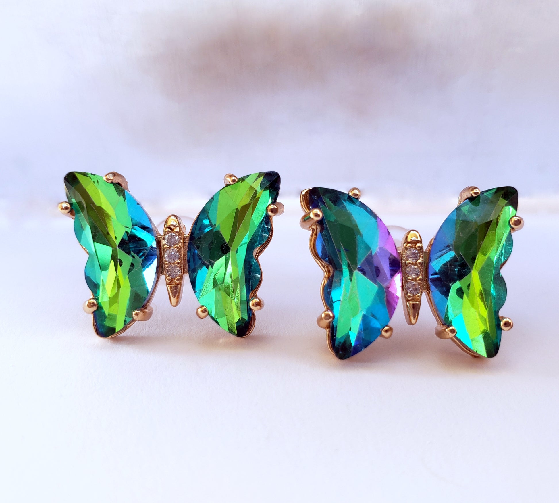 Crystal butterfly stud earrings in peacock green on white background