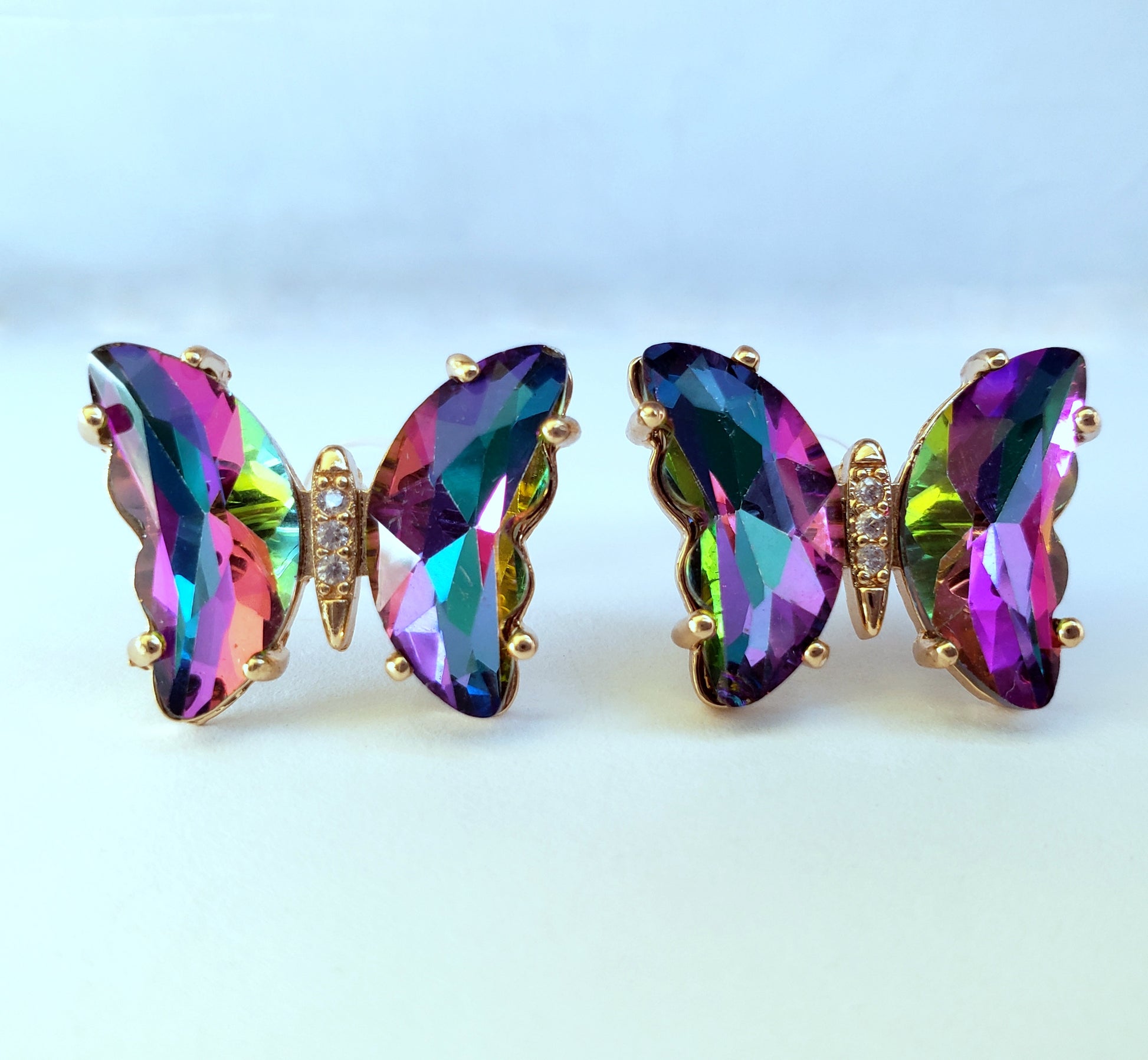 Crystal butterfly stud earrings in rainbow iridescent color on white background