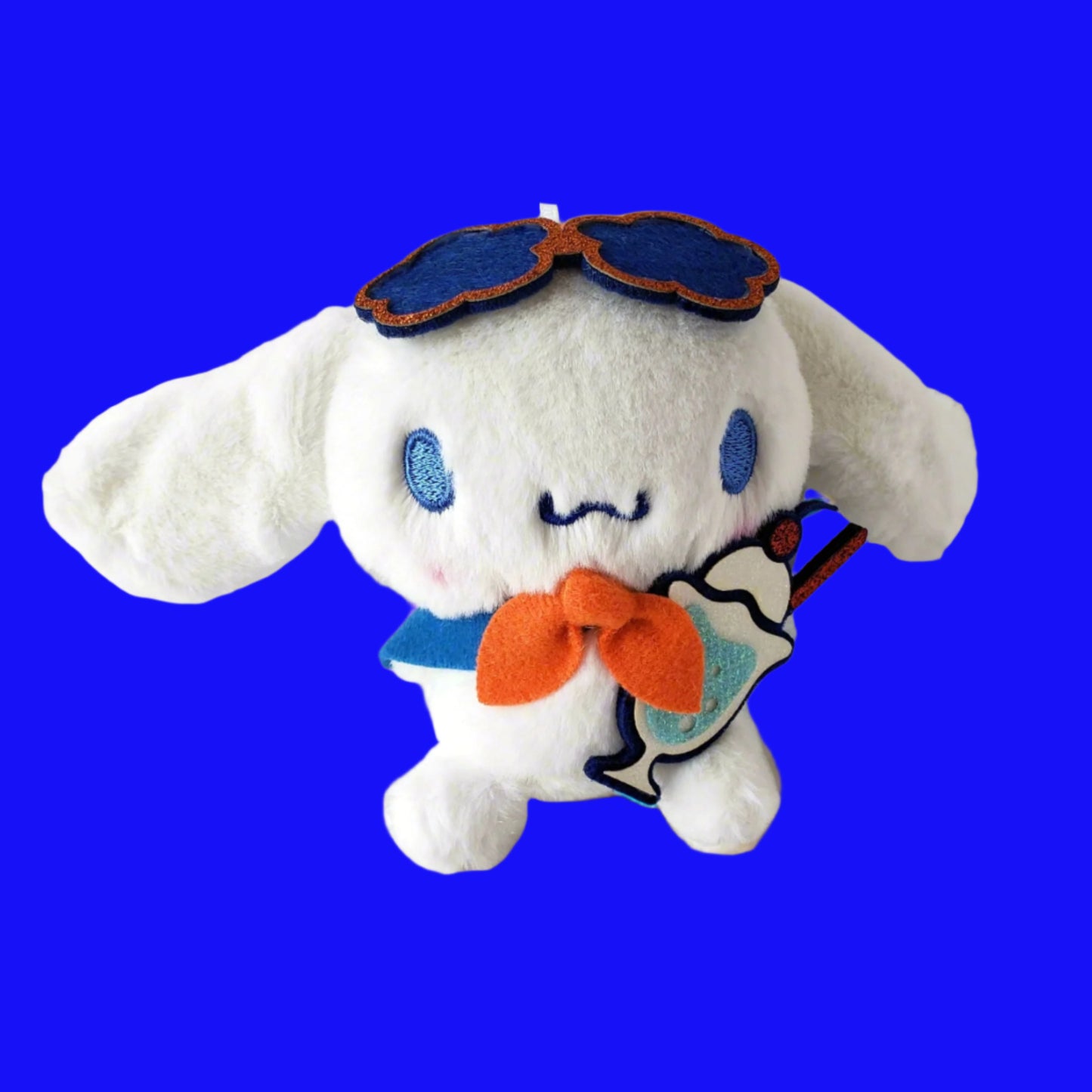 Cinnamoroll Parfait Plush Keychain on bright blue background wearing sunglasses and holding a pastel ice cream soda parfait