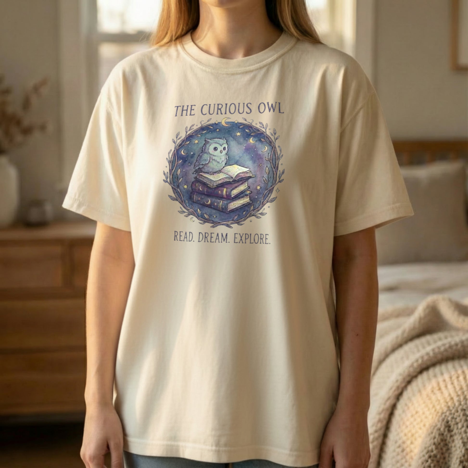 Front view of the Curious Owl tee on an ivory Comfort Colors 1717 shirt with the owl reading books design