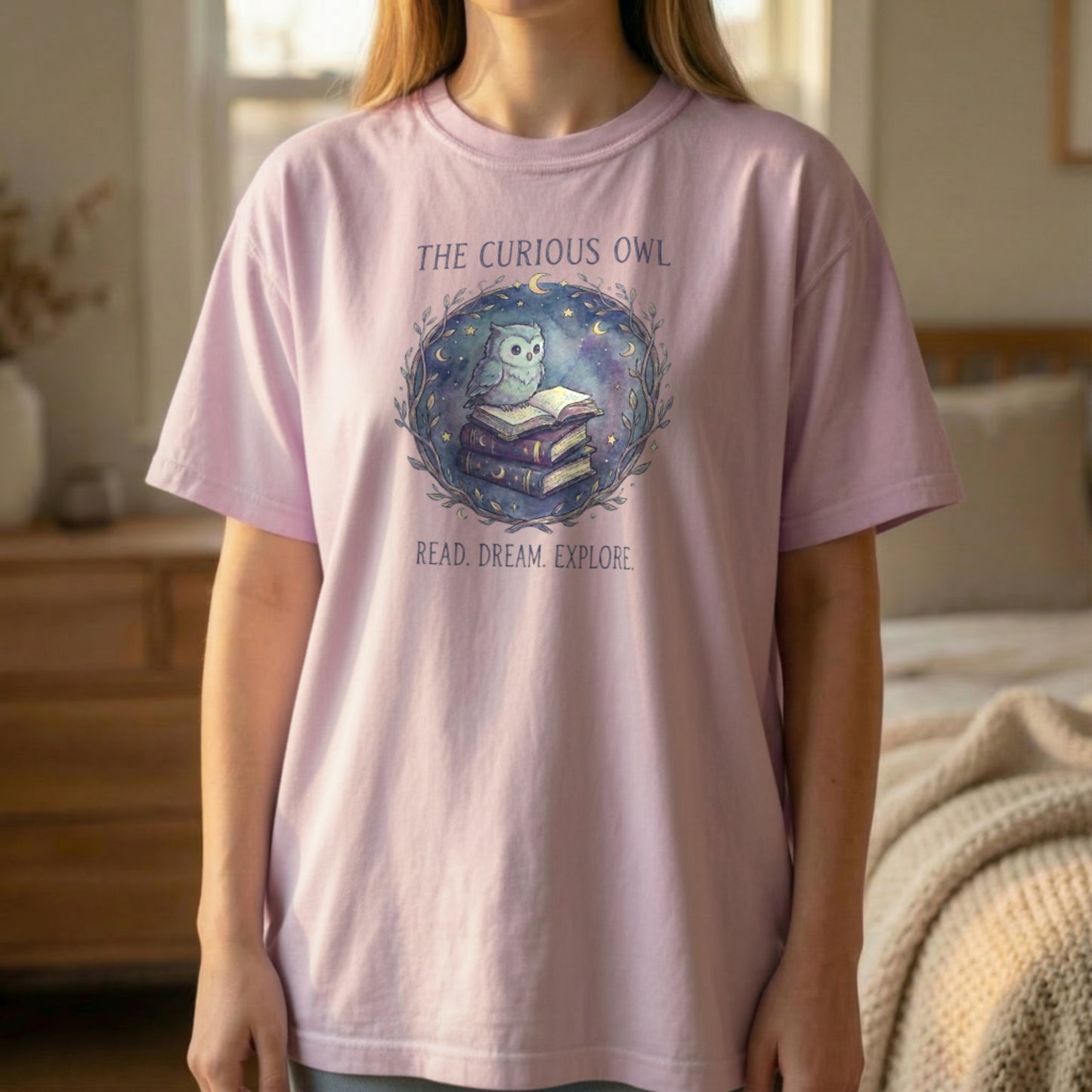 Front view of the Curious Owl tee on an orchid Comfort Colors 1717 shirt with the owl reading books design centered on the chest
