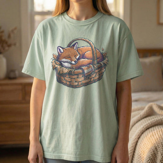 Front view of cute Sleeping Fox in a basket design on Light Green Comfort Colors tee, vintage risograph style.