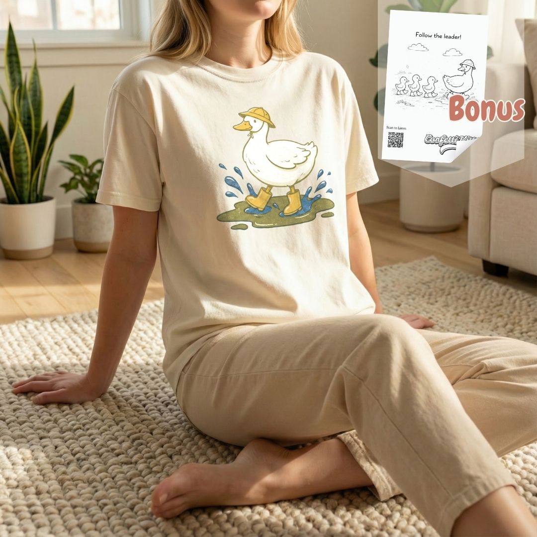 Woman sitting on a rug wearing an ivory duck t-shirt, shown with a free bonus digital coloring page bundle included with purchase.