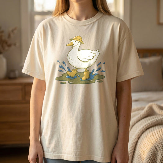 Mockup of a woman standing and wearing an ivory t-shirt with a vintage illustration of a white duck in yellow rain boots.