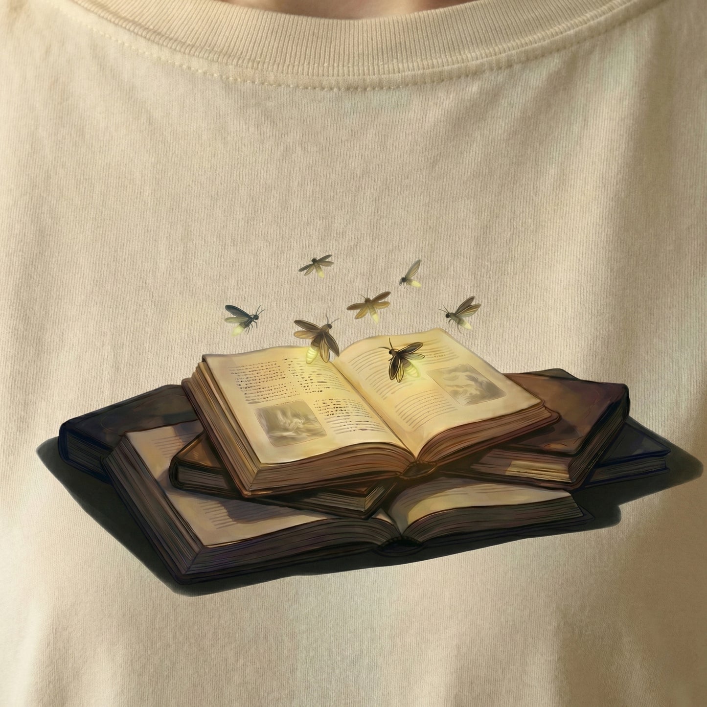 Close-up of Firefly Book tee artwork showing an open book glowing with fireflies