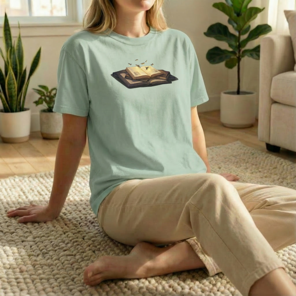 Firefly Book graphic tee in casual floor pose on light green shirt with magical firefly scene