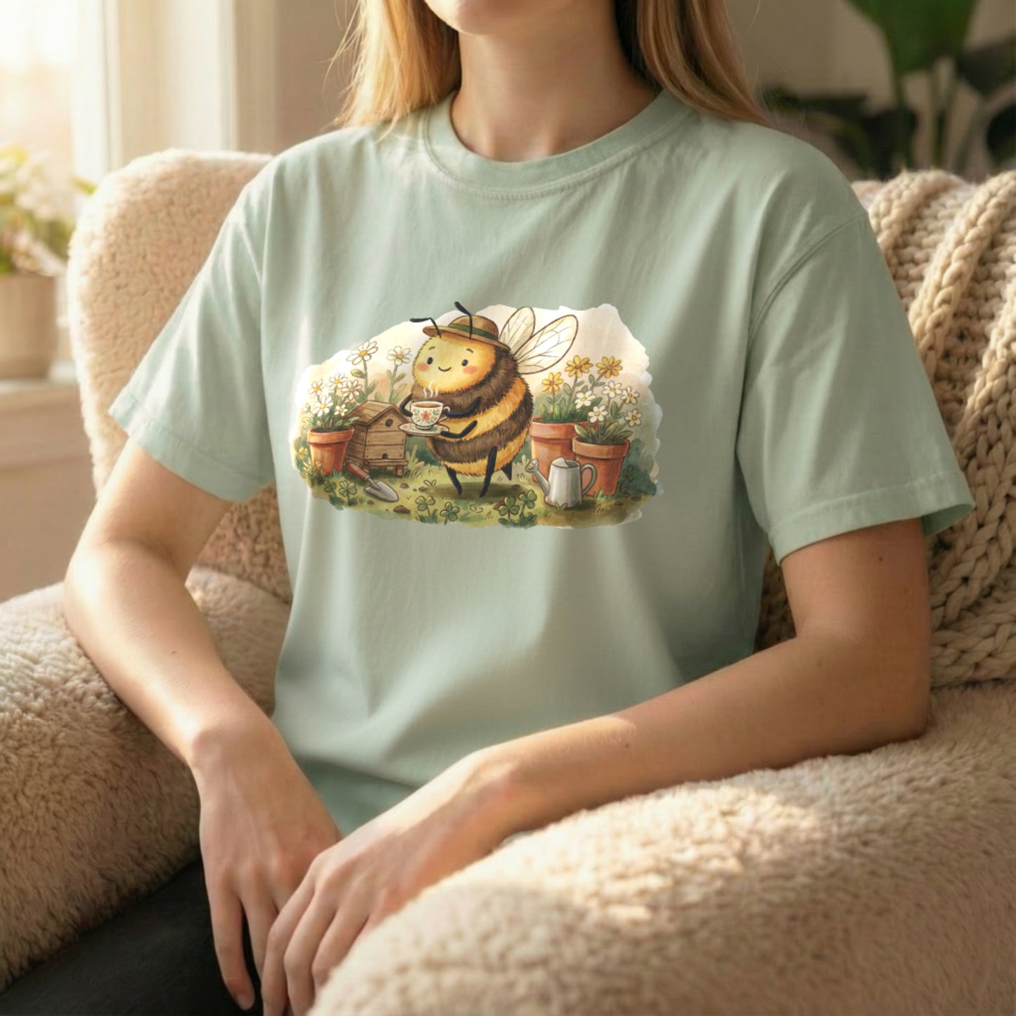 Garden Bee Tee displayed in seated lifestyle pose on light green shirt