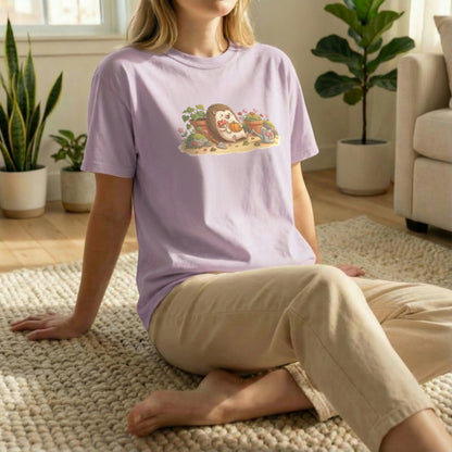 Garden Hedgehog tee worn in relaxed floor pose on orchid shirt with cozy garden hedgehog design