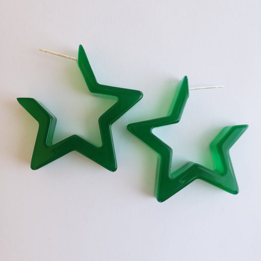 Translucent green star hoop earrings arranged on a white surface