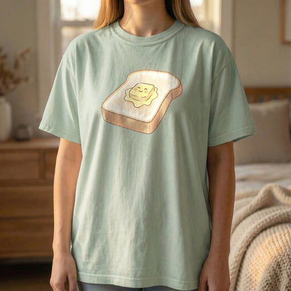 Happy Morning Toast Tee in Light Green, standing pose showing the smiling butter graphic.
