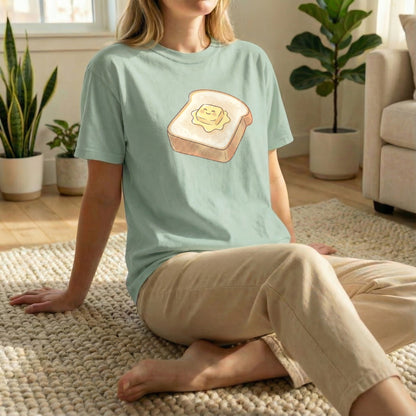 Happy Morning Toast design on a Light Green tee, showing 100% ring-spun cotton texture.