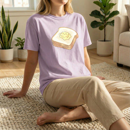 Model sitting on the floor wearing the Orchid Happy Morning Toast tee from the Tiny Treats collection.