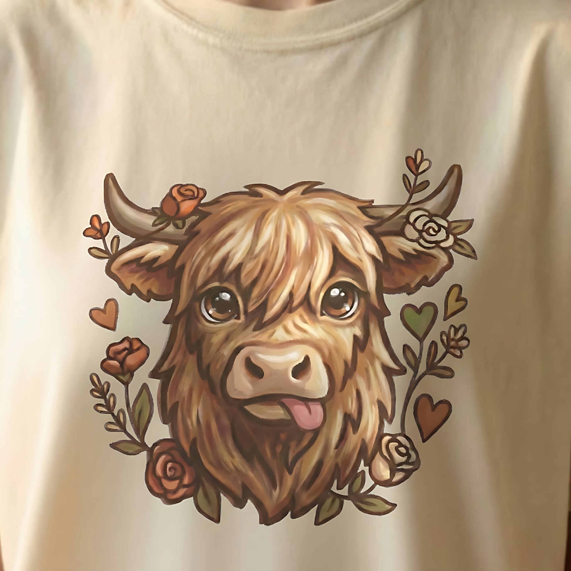 Close-up of Highland cow illustration printed on ivory t-shirt with floral details