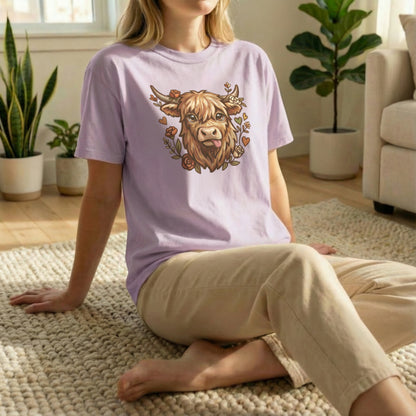 Highland cow illustration tee in orchid shown in casual floor pose