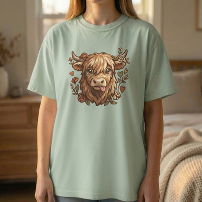 Highland cow illustration t-shirt in light green worn by standing model