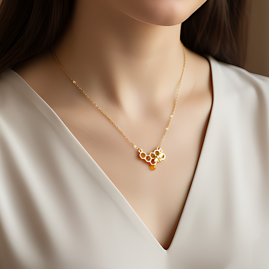 Model wearing honeycomb bee necklace with golden chain and amber detail