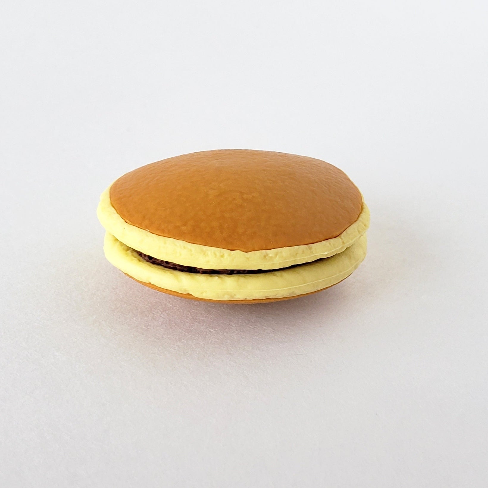 Closeup side view of Iwako Dorayaki Pancake Eraser showcasing its soft vinyl thickness and lifelike pancake profile