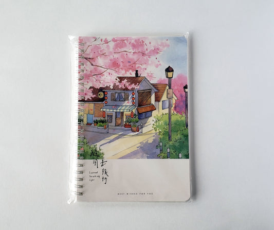 Front view of spiral-bound Daily Journal Notebook featuring cherry blossom tree and Japanese house cover art on a white background