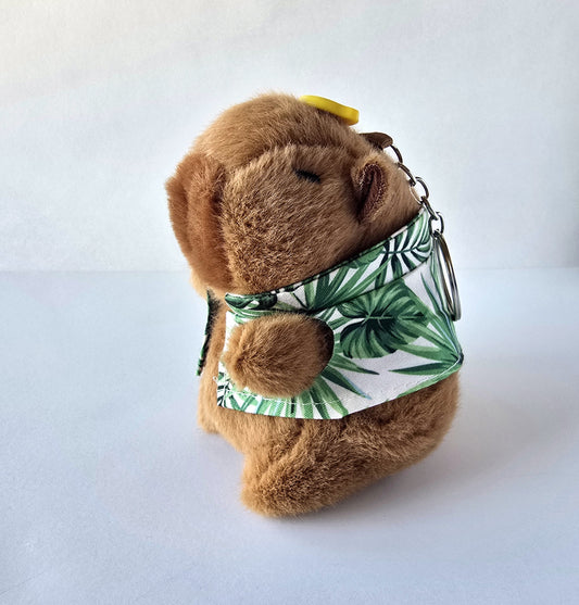 Capybara plush keychain at an angle wearing green leaf shirt