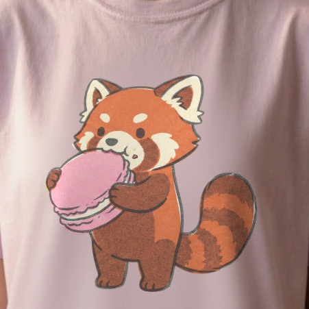 Close-up of Red Panda Macaron Tee design showing red panda gently holding pink heart-shaped macaron