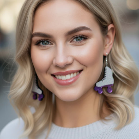 Smiling woman wearing glittery retro roller skate dangle earrings with purple wheels