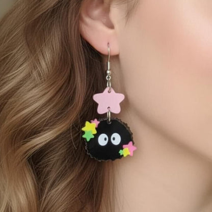 Close-up of Starry Sprite acrylic earrings with colorful stars and pink star topper worn on ear